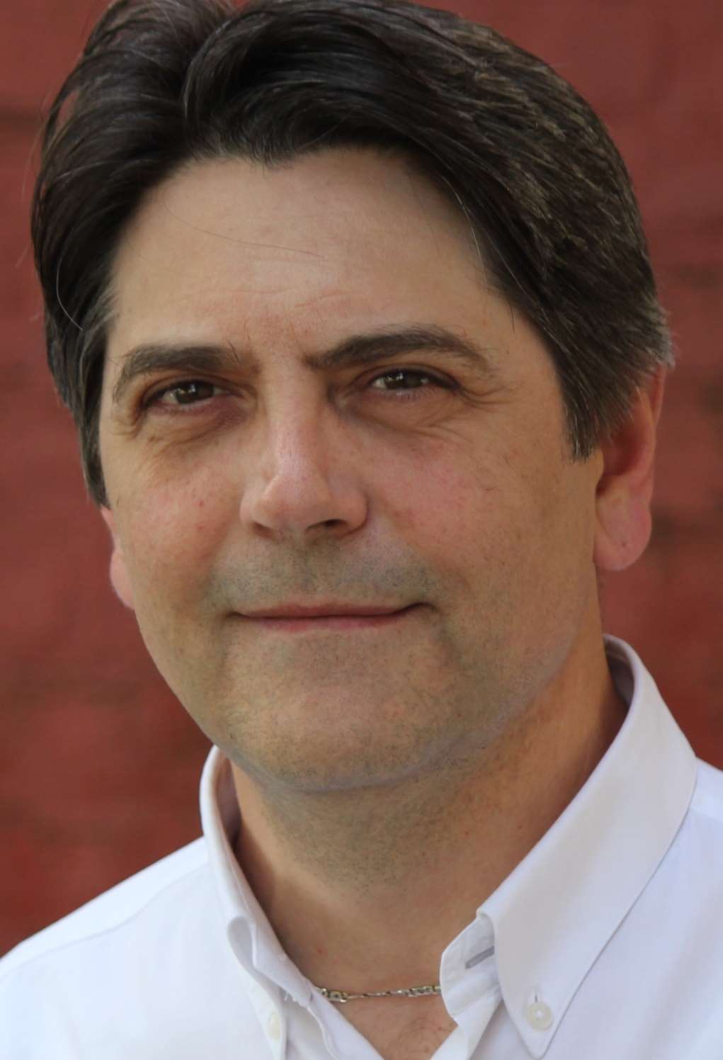 Man in white shirt, neutral background.
